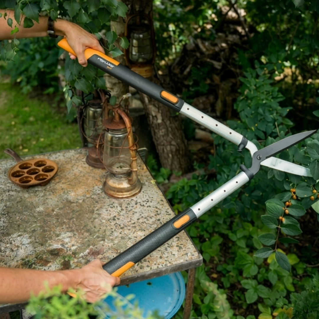 Nožnice na živý plot fiskars hs86 smartfit teleskopické 04 | záhradníctvo garden team Čierno oranžové teleskopické nožnice na živý plot fiskars hs86 smartfit s ostrými oceľovými čepeľami počas práce v zájrade